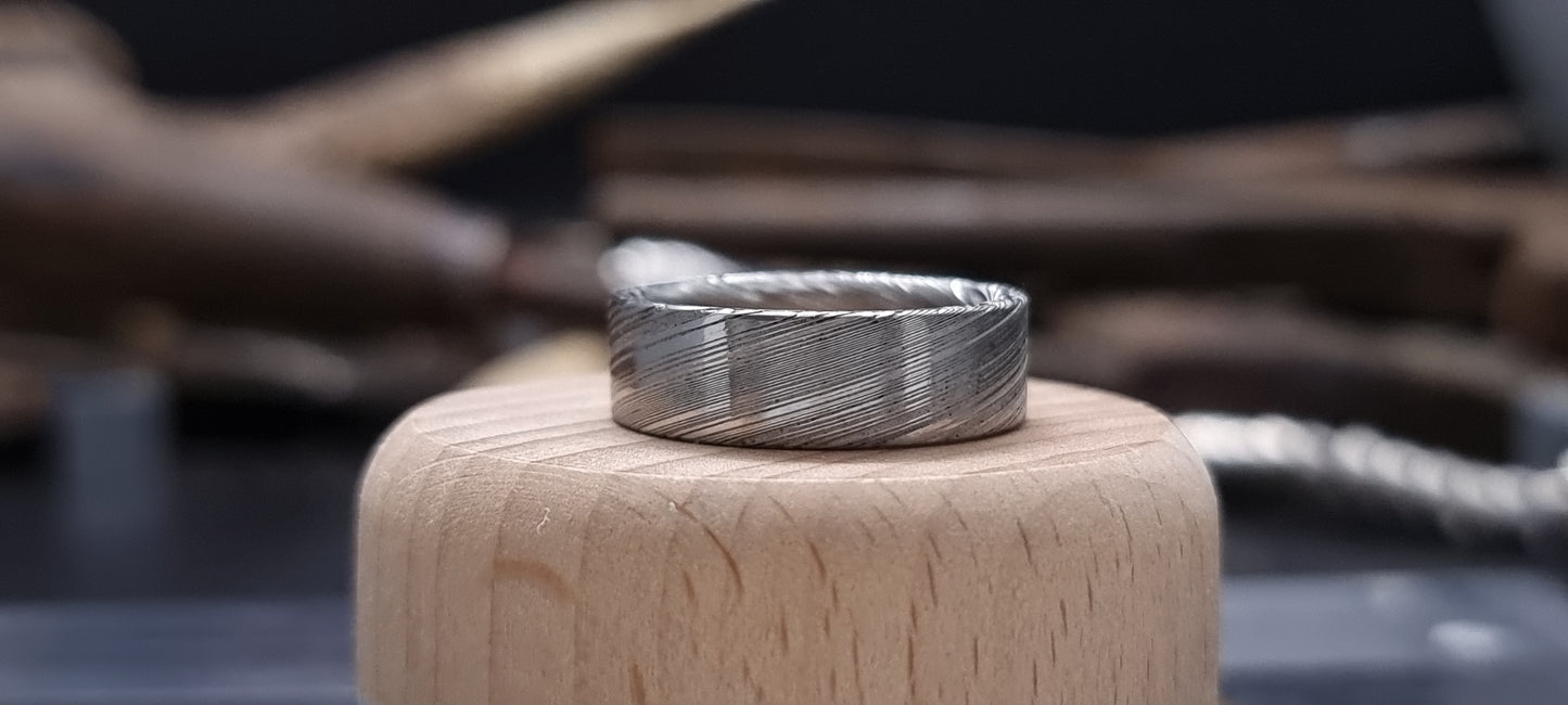 Men’s flat Damascus steel wedding band with bold natural etching
