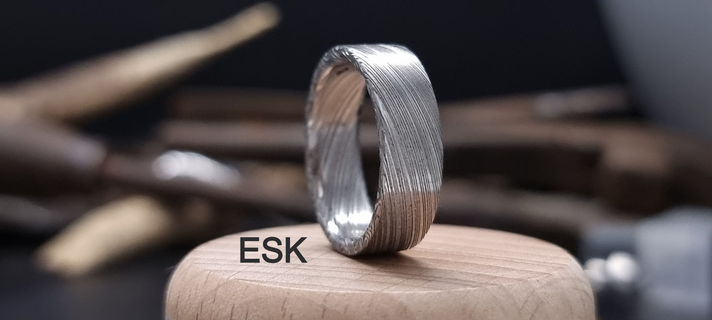 Unique men’s wedding ring combining Damascus steel and gold inlay