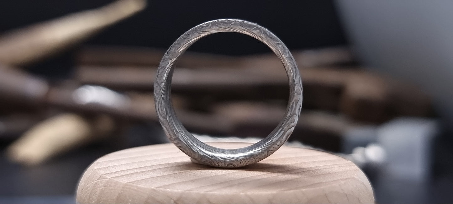 Men’s flat Damascus steel wedding band with bold natural etching