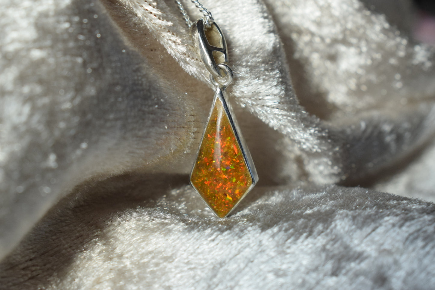 Kite-shaped silver memorial necklace with cremation ashes inside