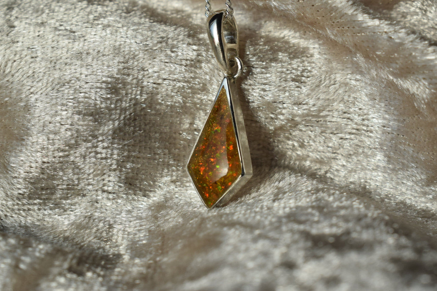 Kite-shaped silver memorial necklace with cremation ashes inside
