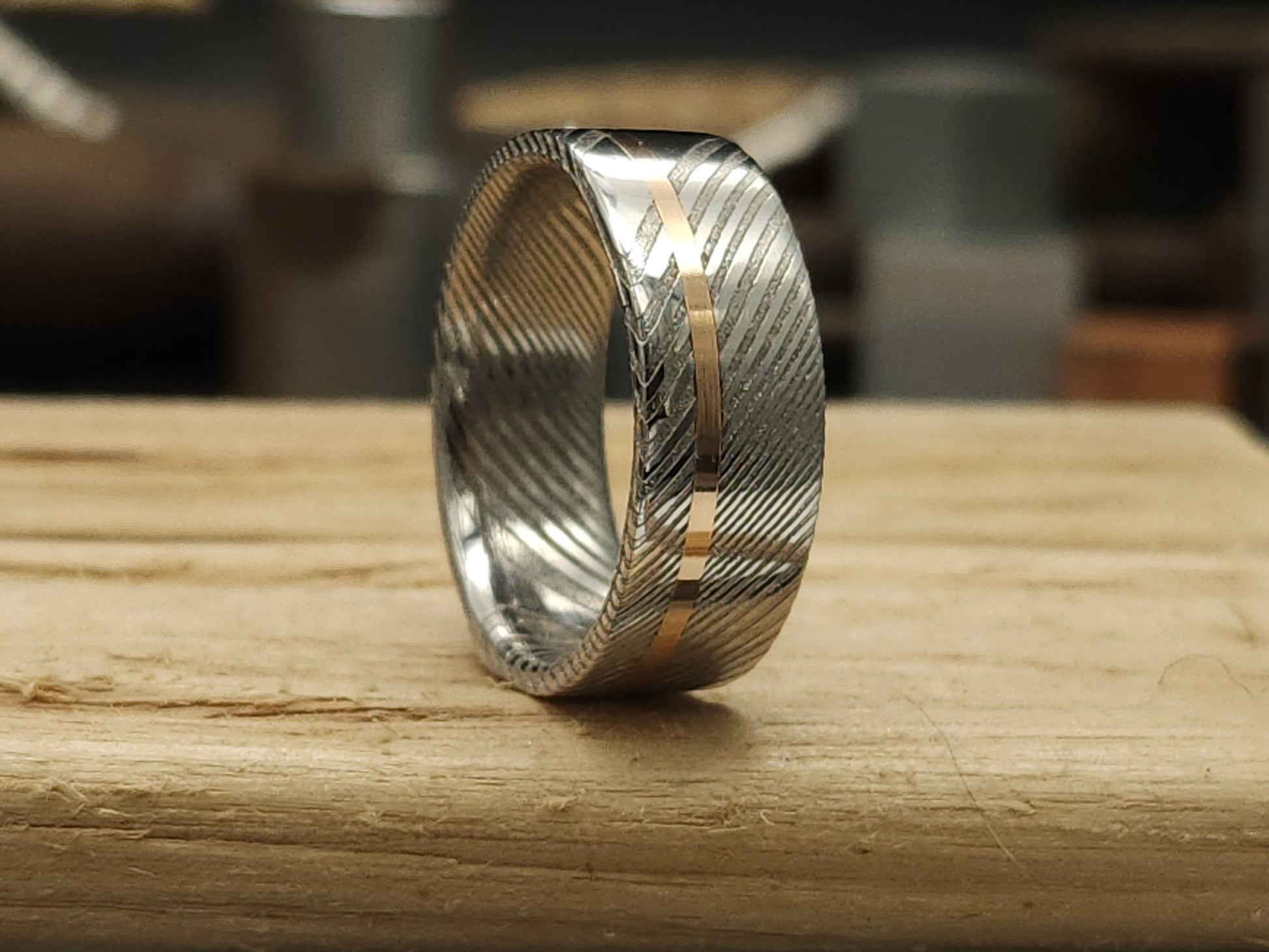 Unique men’s wedding ring combining Damascus steel and  gold inlay
