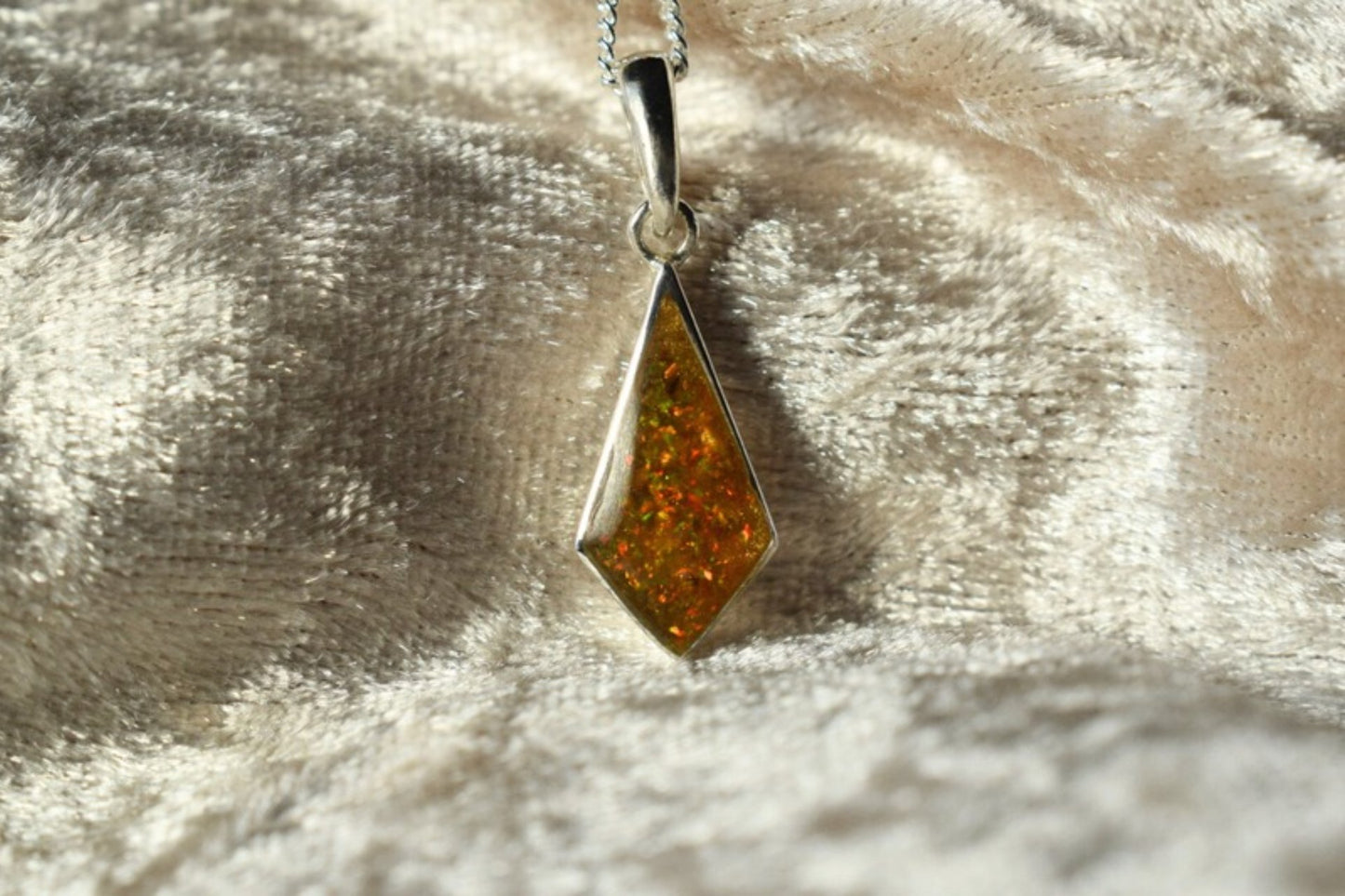 Kite-shaped silver memorial necklace with cremation ashes inside