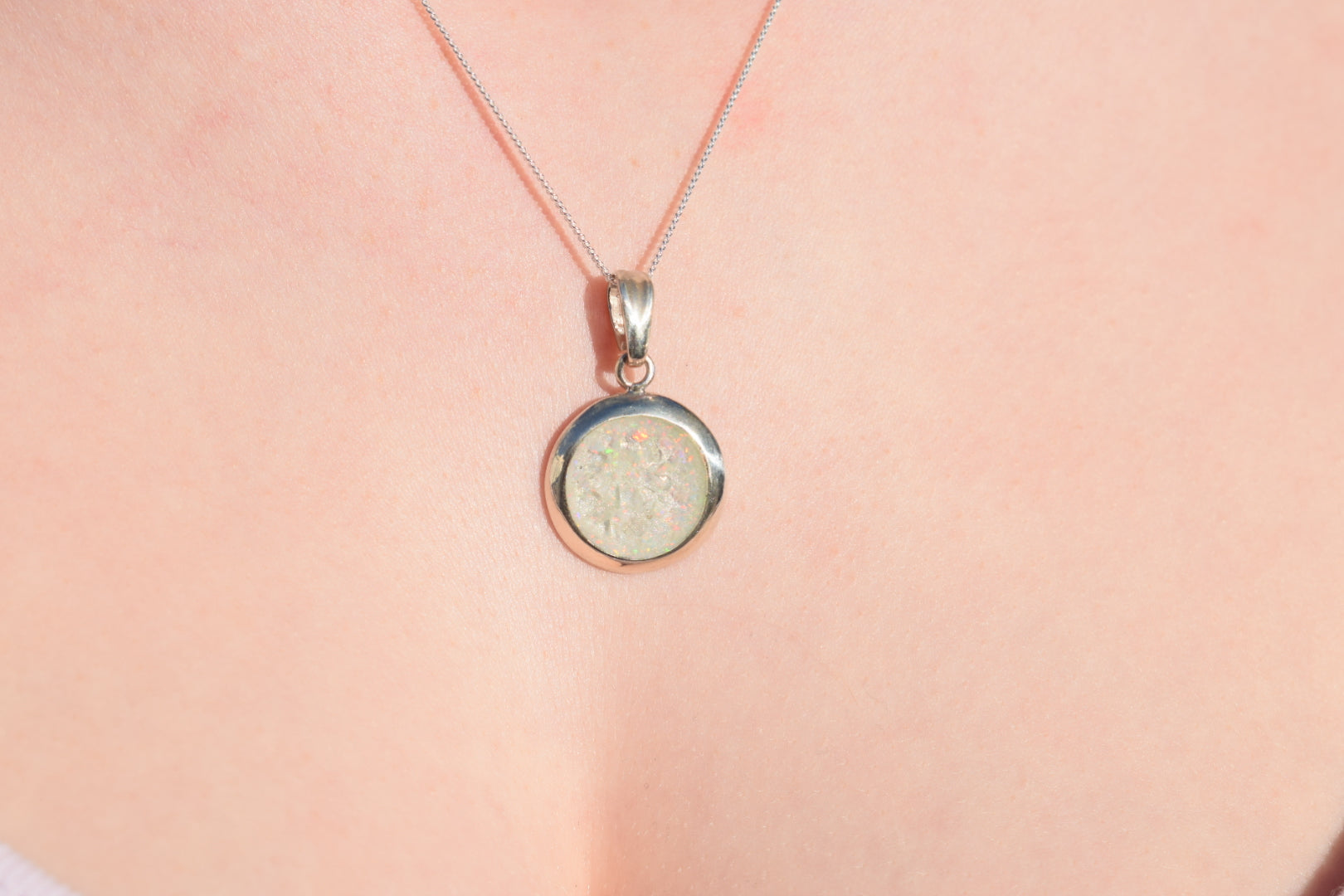 Large round silver cremation ashes necklace featuring a subtle and timeless design. Crafted from high-quality sterling silver, this handmade necklace preserves precious memories and offers a comforting keepsake. Designed in the UK, the necklace combines elegance and meaning, making it an ideal memorial jewellery piece.