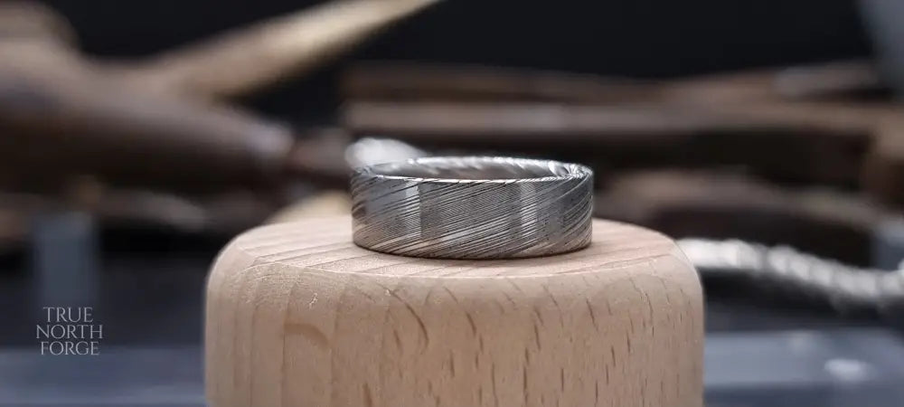 Men’s flat Damascus steel wedding band with bold natural etching
