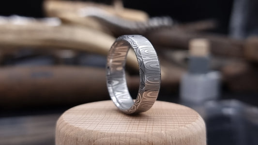 Close-up of handcrafted Damascus steel wedding band with bevel edge
