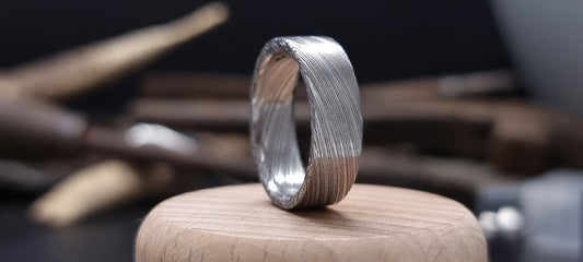 Men’s flat Damascus steel wedding band with bold natural etching